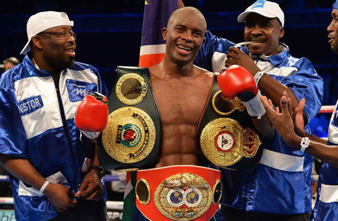 Julius Indongo - holding his World Title belts with his team. Photo Credit: Powcast Sports Hub